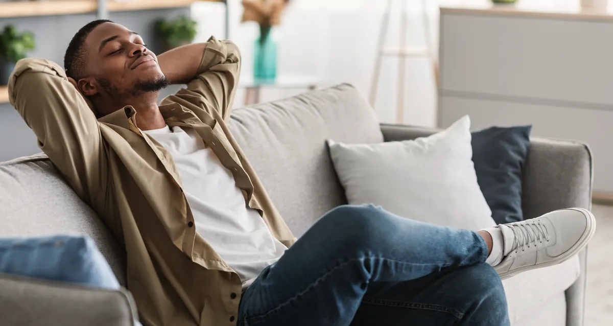 A man resting comfortably on his couch at home
